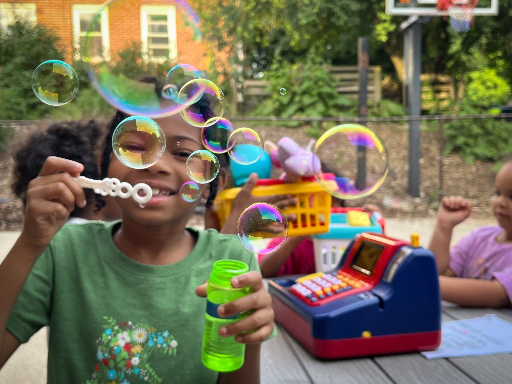 Child smiling while blowing bubbles